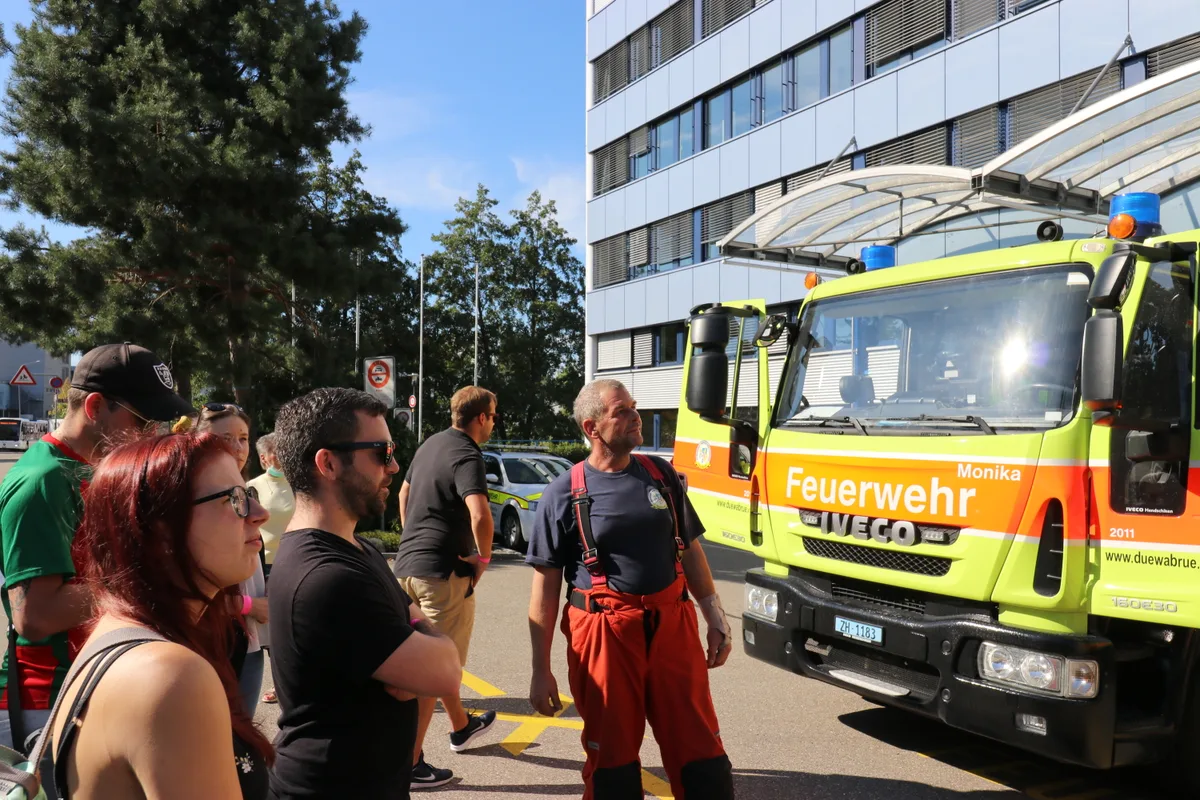 Mehrere Personen stehen vor einem Feuerwehrauto. 